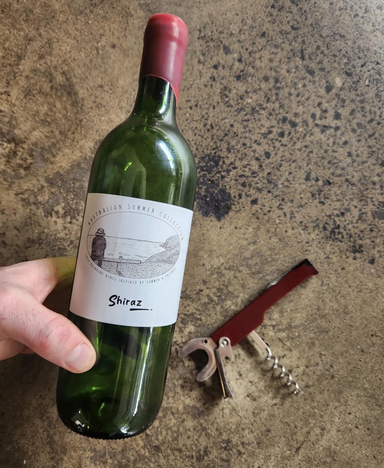 An earlier Nick's Wine Co. Shiraz bottle beside a corkscrew